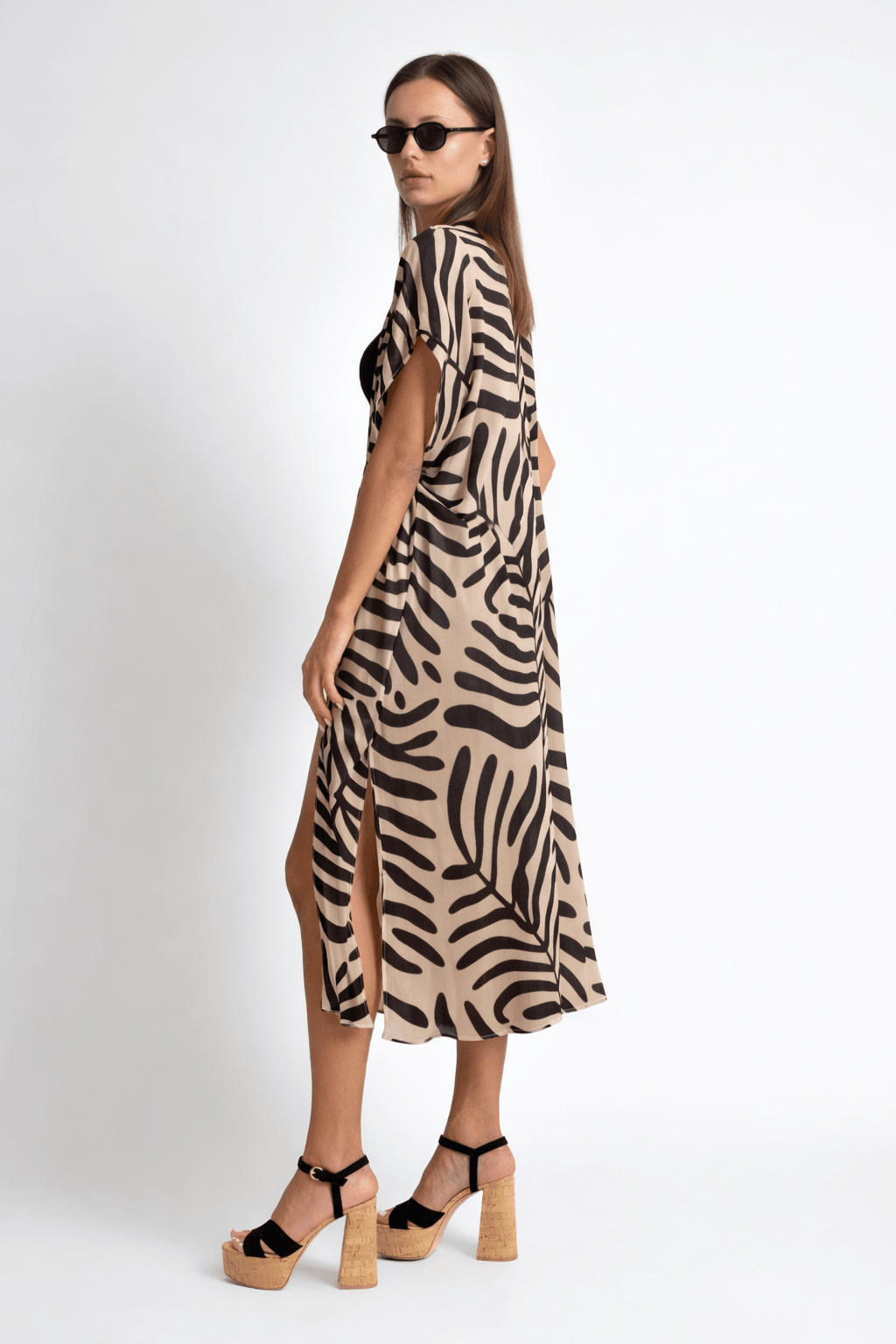 Woman wearing a zebra print dress on a white background