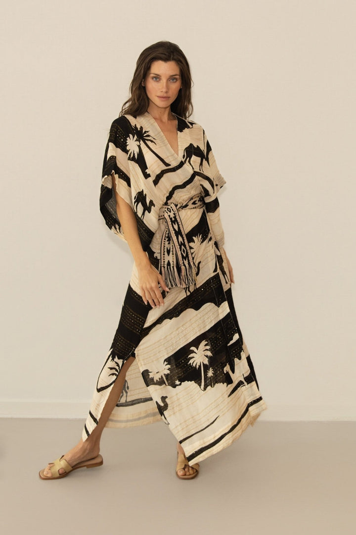 Woman wearing a black and white patterned dress against a plain background