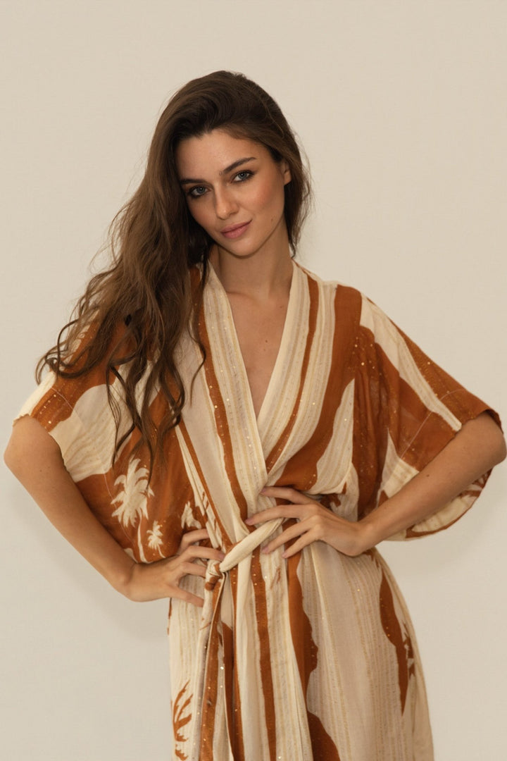 Woman wearing a patterned dress against a plain background