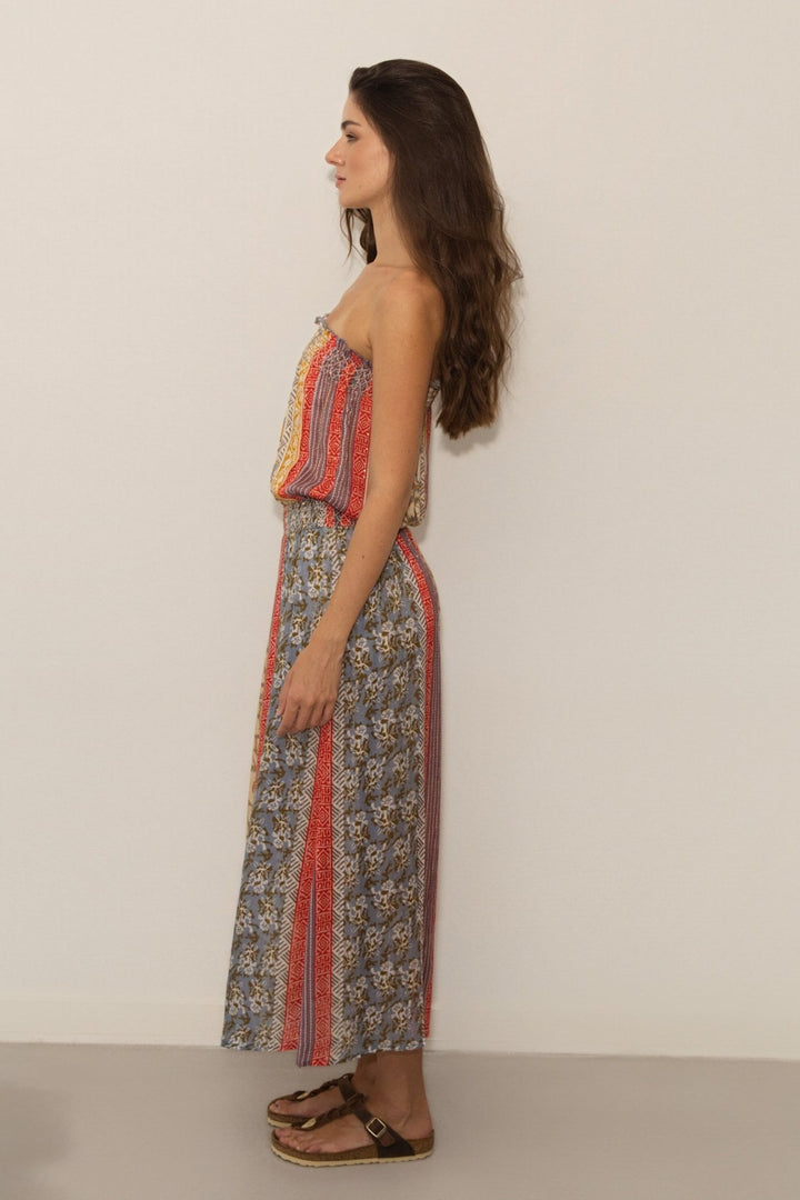 Woman wearing a colorful patterned dress against a plain background