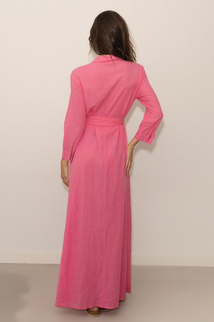Woman wearing a pink dress against a plain background