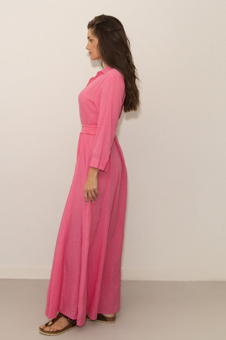 Woman wearing a pink dress against a plain background