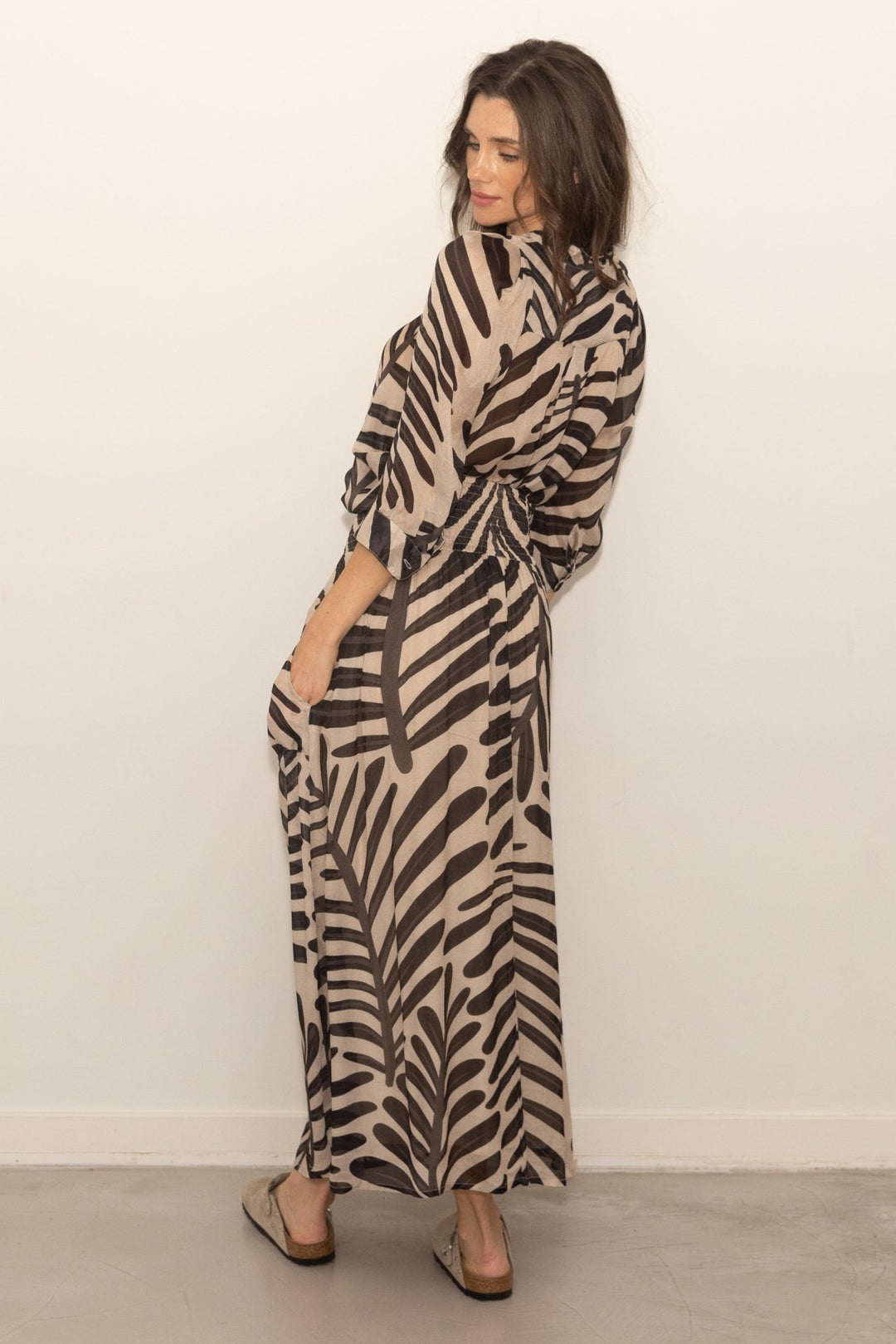 Woman wearing a zebra print dress against a plain background