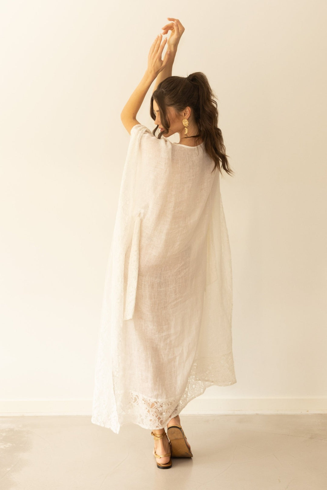 Woman wearing a white dress with a plain background