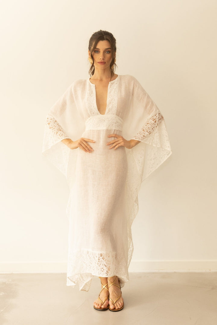 Woman wearing a white lace dress against a plain background