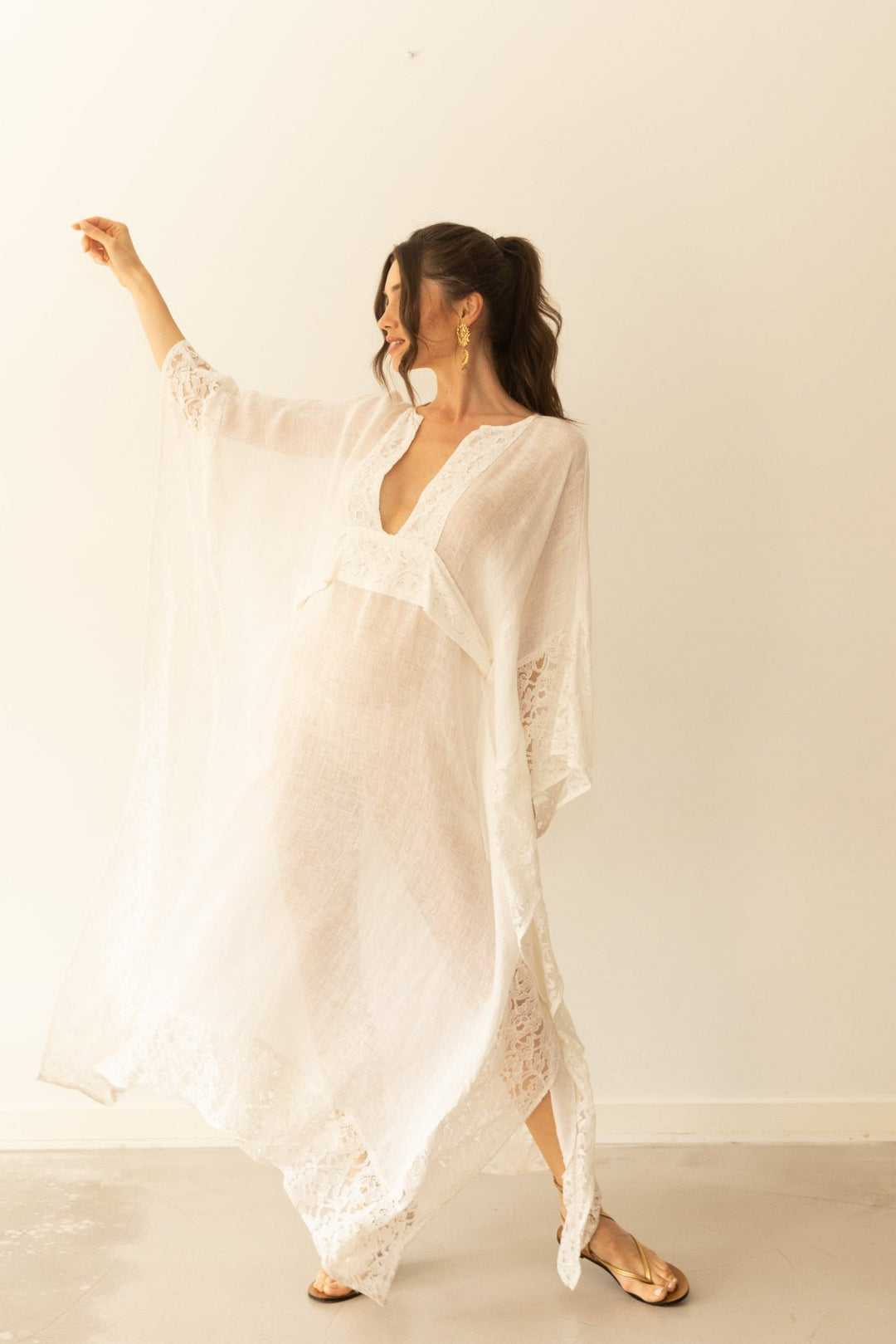 Woman wearing a white lace dress against a plain background