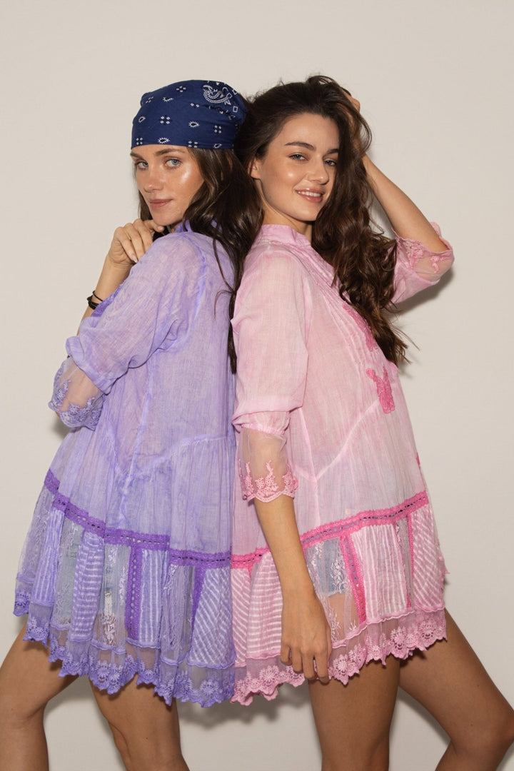 Two women wearing pastel-colored nightgowns against a plain background