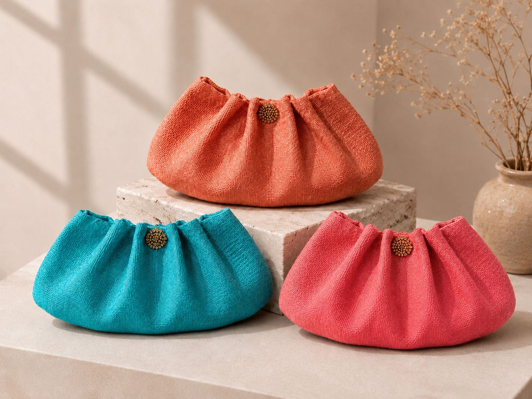 Three colorful fabric bags (orange, blue, red) on a neutral background